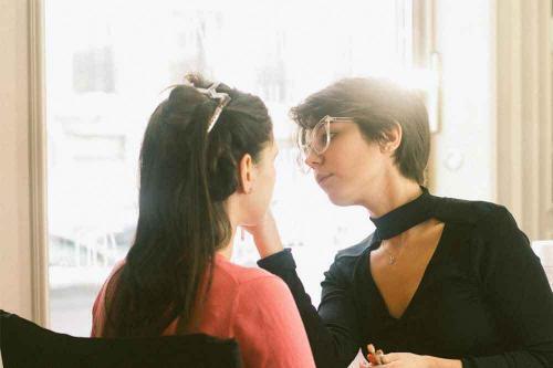 髪をダッカールでとめて化粧をする女性