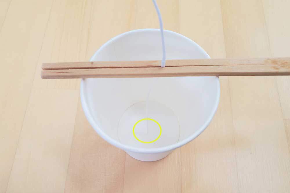 ろうそくの芯を割りばしで挟む