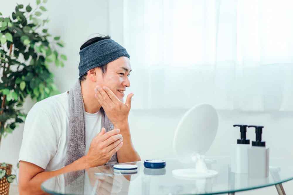 髭剃り後に肌ケアする男性