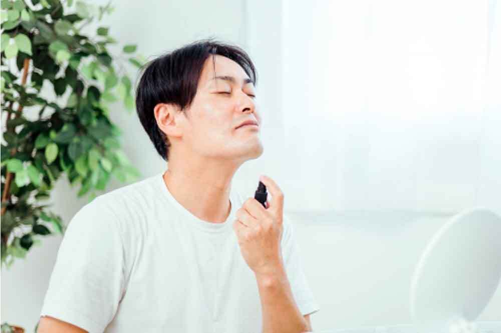 顔用の制汗剤をつける男性