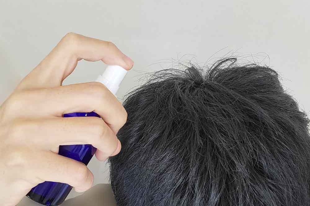 髪をしっかり乾かしてから育毛剤をつける男性