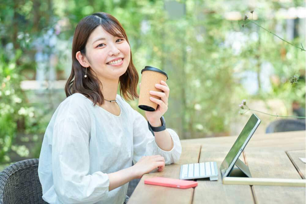 コーヒーを飲みながら勉強する女性