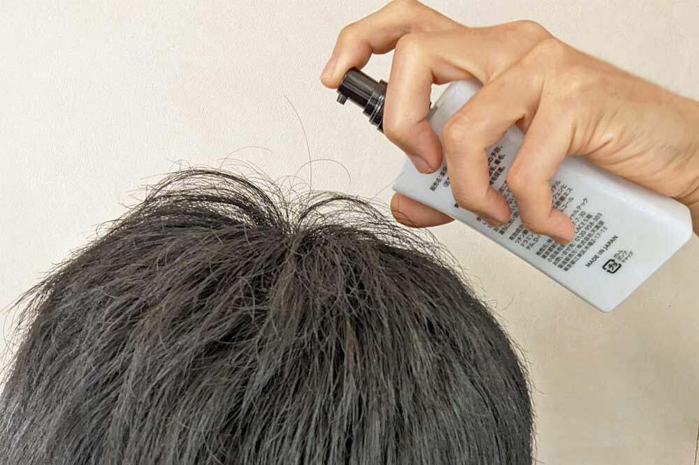 育毛剤チャップアップを髪につける男性