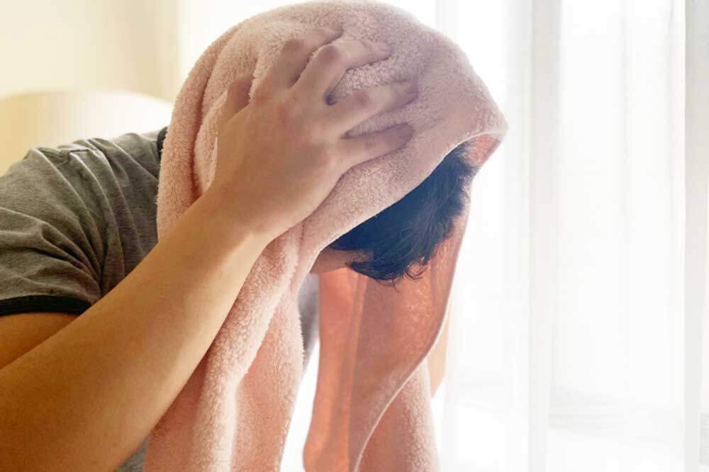 タオルで濡れた髪を拭く男性