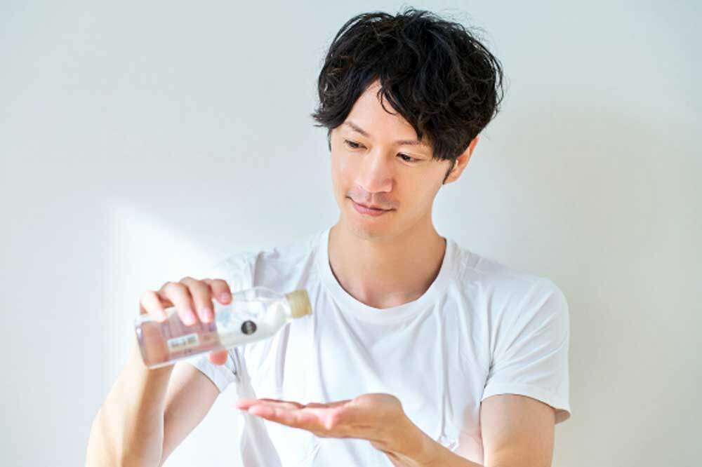 ヘアオイルをつける男性