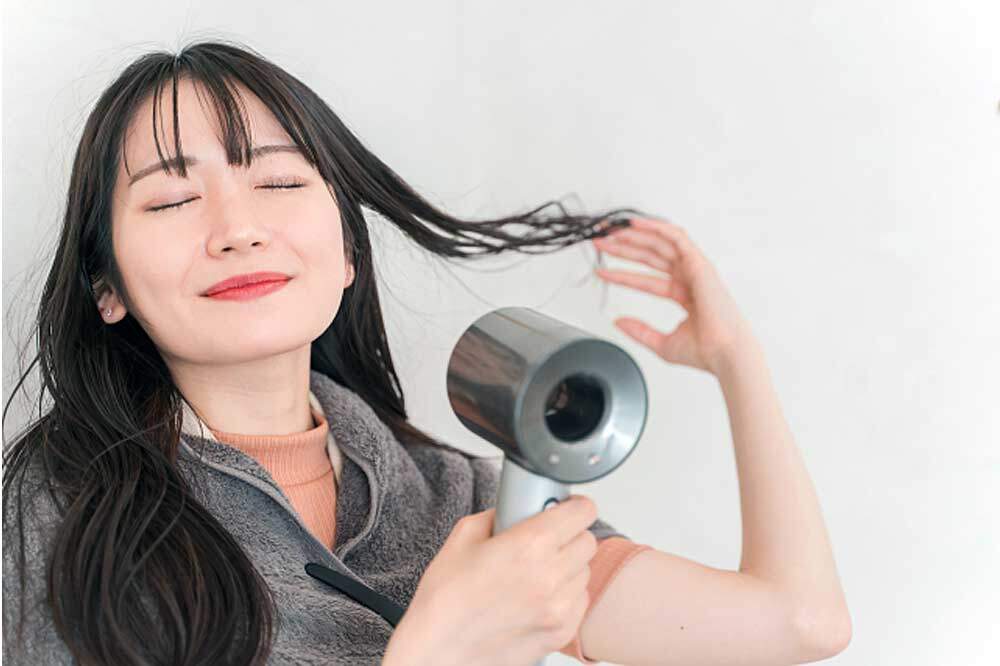 うるツヤになった髪を乾かす女性