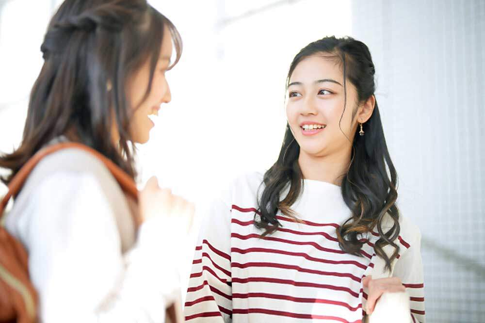 友達の髪型を参考にする女性