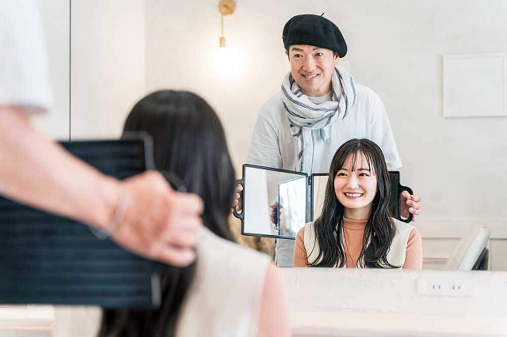 ヘアカットの仕上がりを確認してもらう美容師