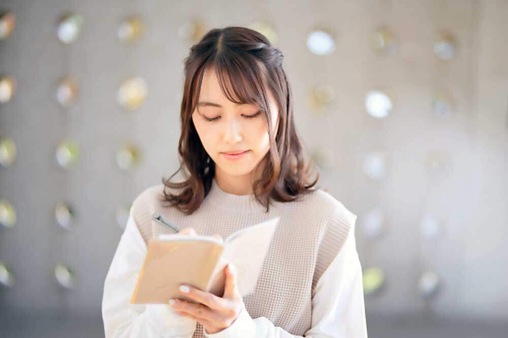 美容院に求めることをメモする女性
