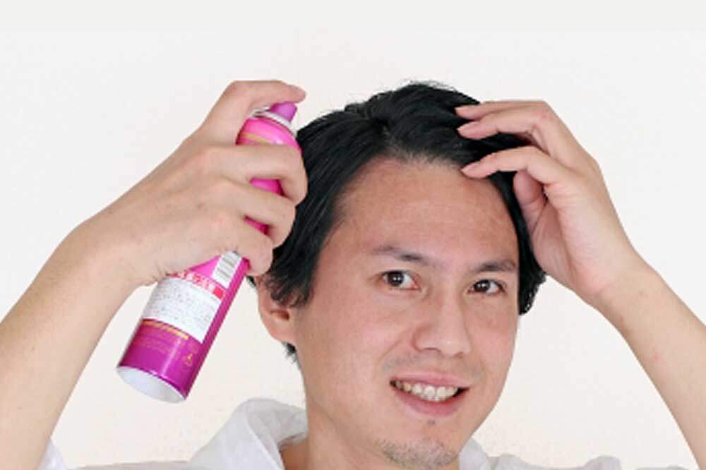 ヘアスプレーを使う男性