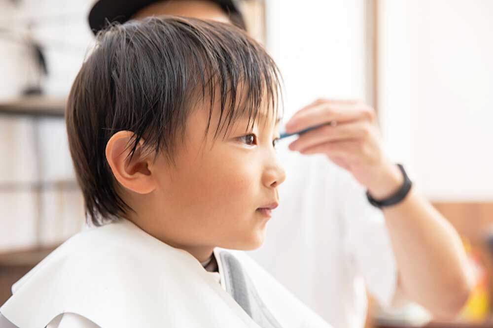 床屋さんで髪を切るこども